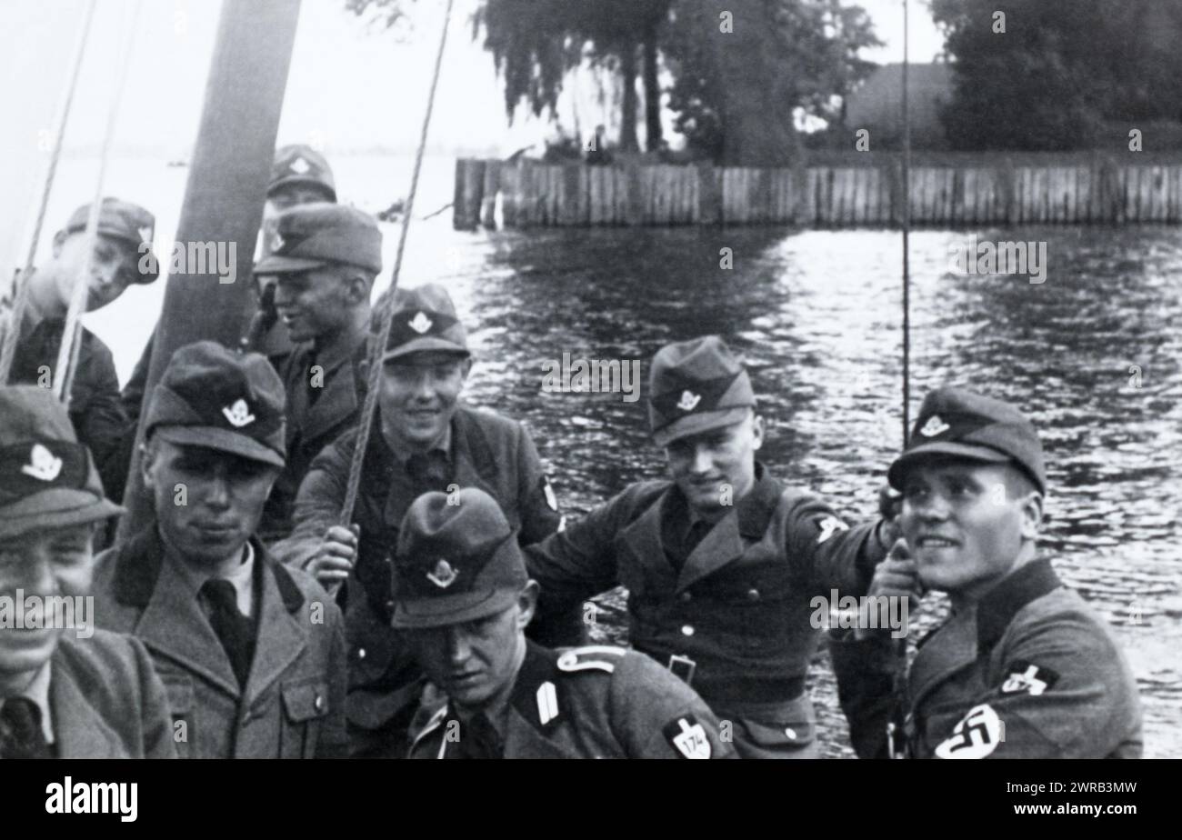 Ein Truppenführer und arbeitende Männer des Reichsarbeitsdienstes auf einem Segelboot während des Deutschen Dritten Reichs. Stockfoto