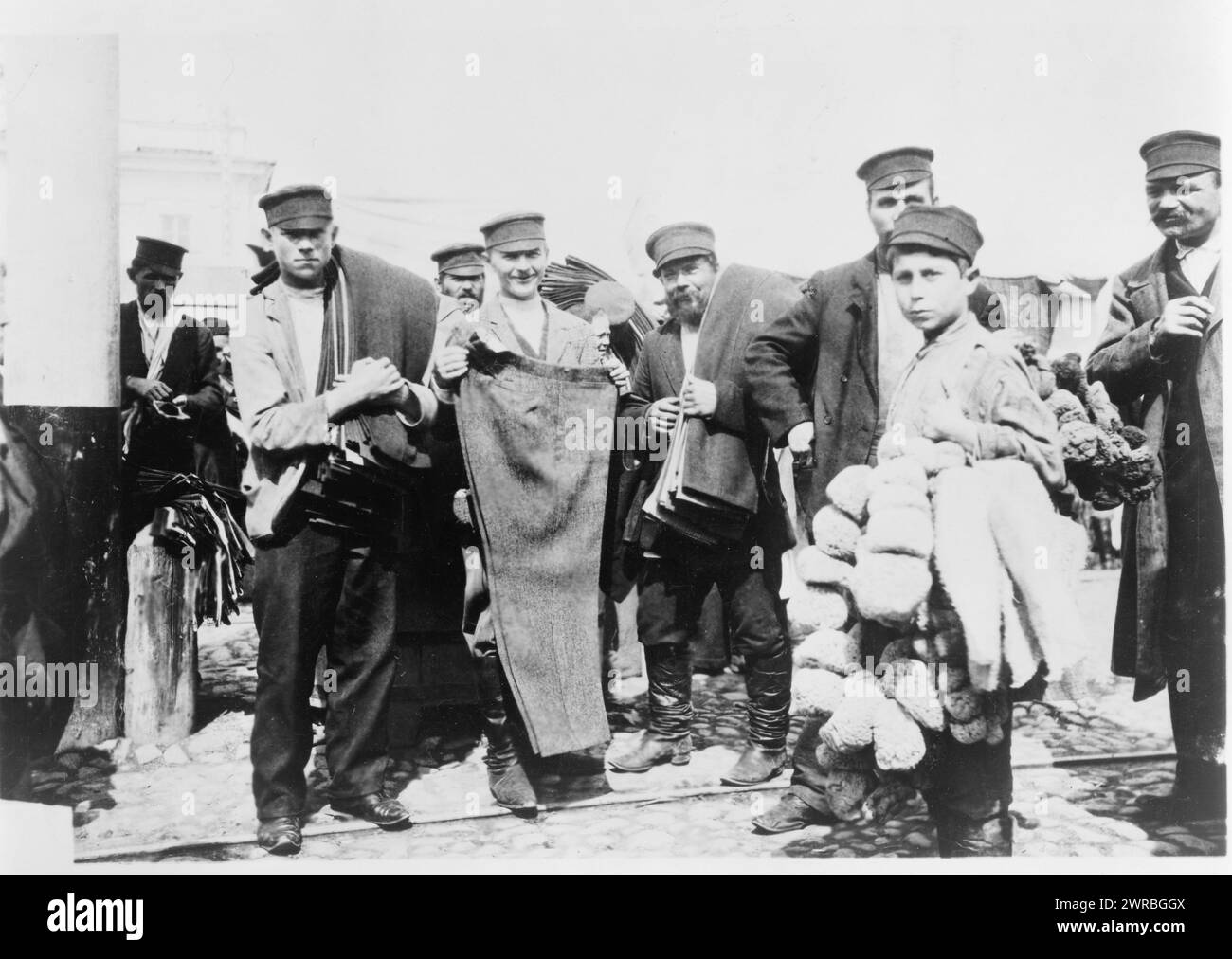 Glocken zum Verkauf Bekleidungsmarkt., Fotos zeigen (oben) Ausstellungsfläche für große Glocken, die an Querträgern hängen; (unten) mehrere Männer, einige tragen Hosen und einen Jungen, der Produkte für den Markt trägt., Zimmermann, Frank G. (Frank George), 1855-1924, Fotograf, zwischen 1880 und 1924, Bells, Russland, 1880-1930, Fotodrucke, 1880-1930., Fotodrucke, 1880-1930, 2 Fotodrucke: auf Karte montiert, 5 x 7 Zoll (Foto Stockfoto