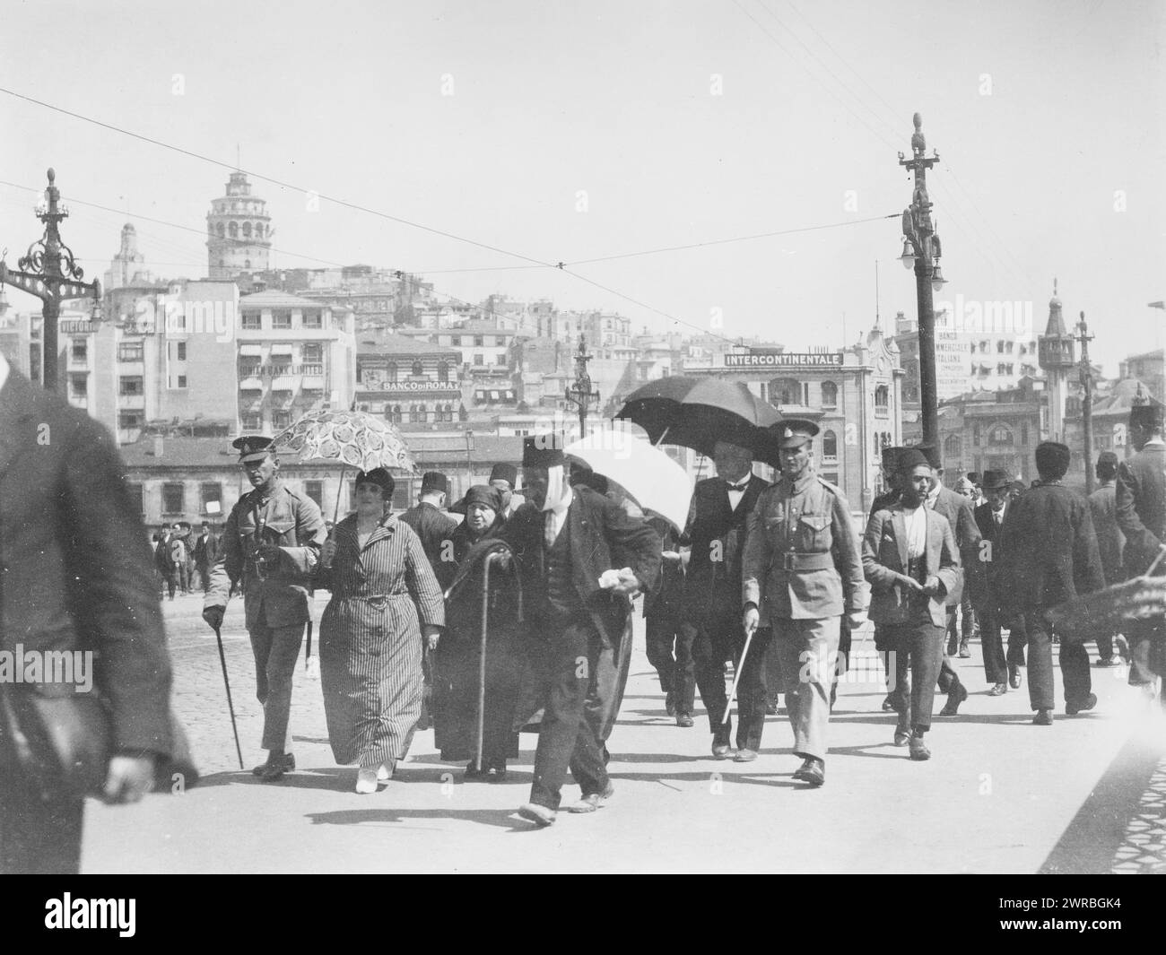 Menschen gehen auf einer Straße in Istanbul, Türkei, mit Wachturm in der Ferne, 1923., City & Town Life, Türkei, Istanbul, 1920-1930, Fotodrucke, 1920-1930., Fotodrucke, 1920-1930, 1 Fotodruck Stockfoto