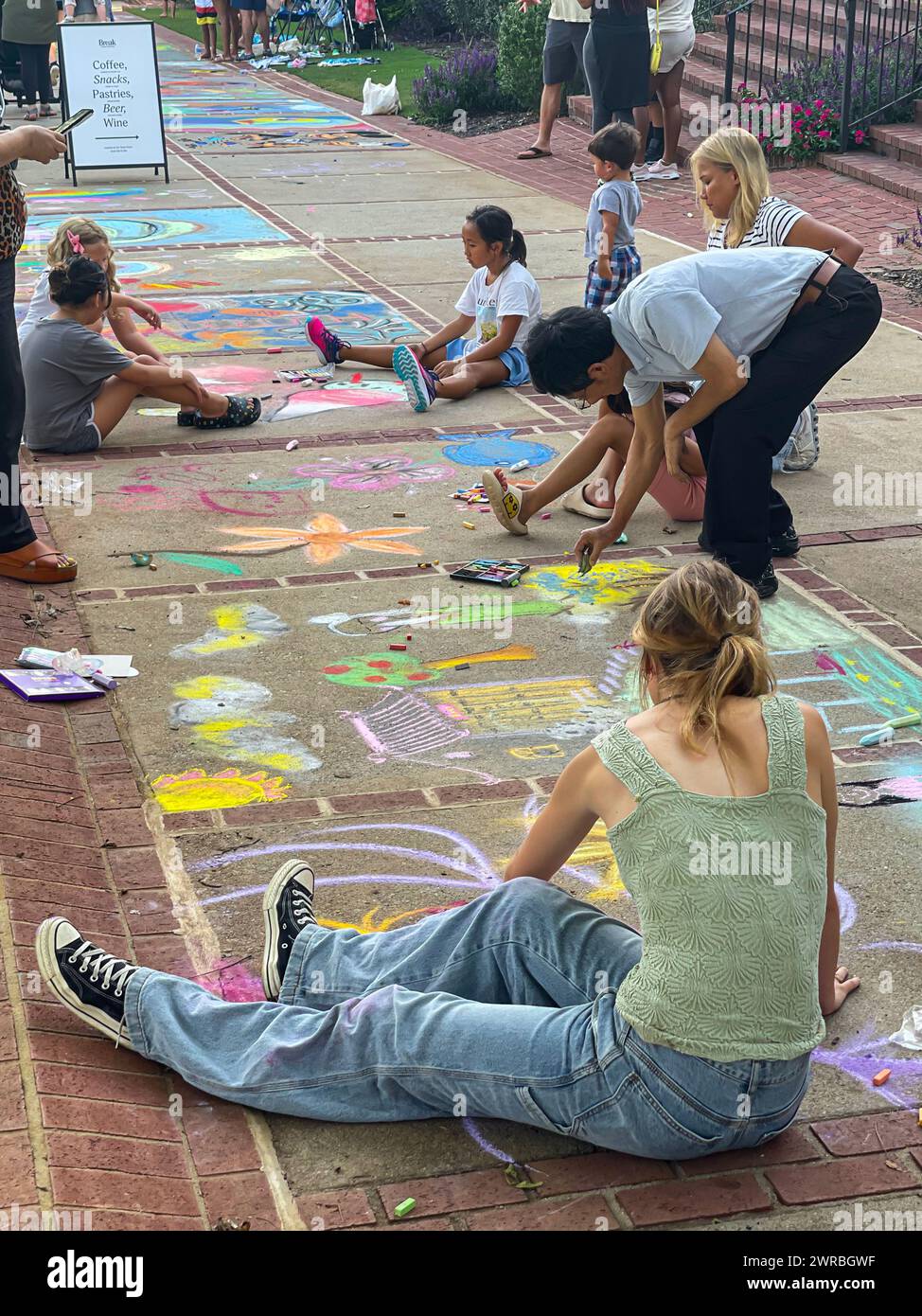 Duluth, GA / USA – 11. August 2023: Menschen zeichnen mit Kreide auf dem Bürgersteig, während sie am 11. August 2023 an einem Kreidekunstfestival in Duluth teilnehmen. Stockfoto
