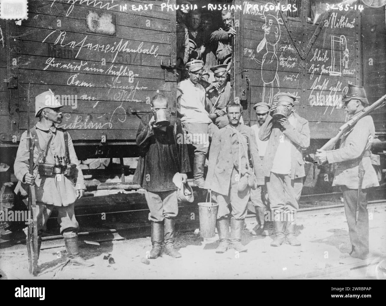 In Ostpreußen, russische Gefangene, Foto zeigt russische Gefangene, die bei einem Eisenbahnwagen stehen und während des Ersten Weltkriegs aus großen Bechern trinken, 1914, Weltkrieg, 1914-1918, Glasnegative, 1 negativ: Glas Stockfoto