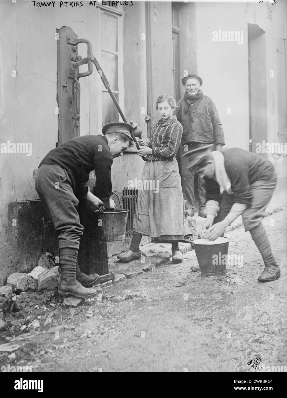 Tommy Atkins in Etaples, Foto zeigt zwei britische Soldaten namens „Tommys“, die einigen Anwohnern während des Ersten Weltkriegs zwischen 1914 und ca. an einer Wasserpumpe in Etaples, Frankreich, helfen. 1915, Weltkrieg, 1914-1918, Glasnegative, 1 negativ: Glas Stockfoto