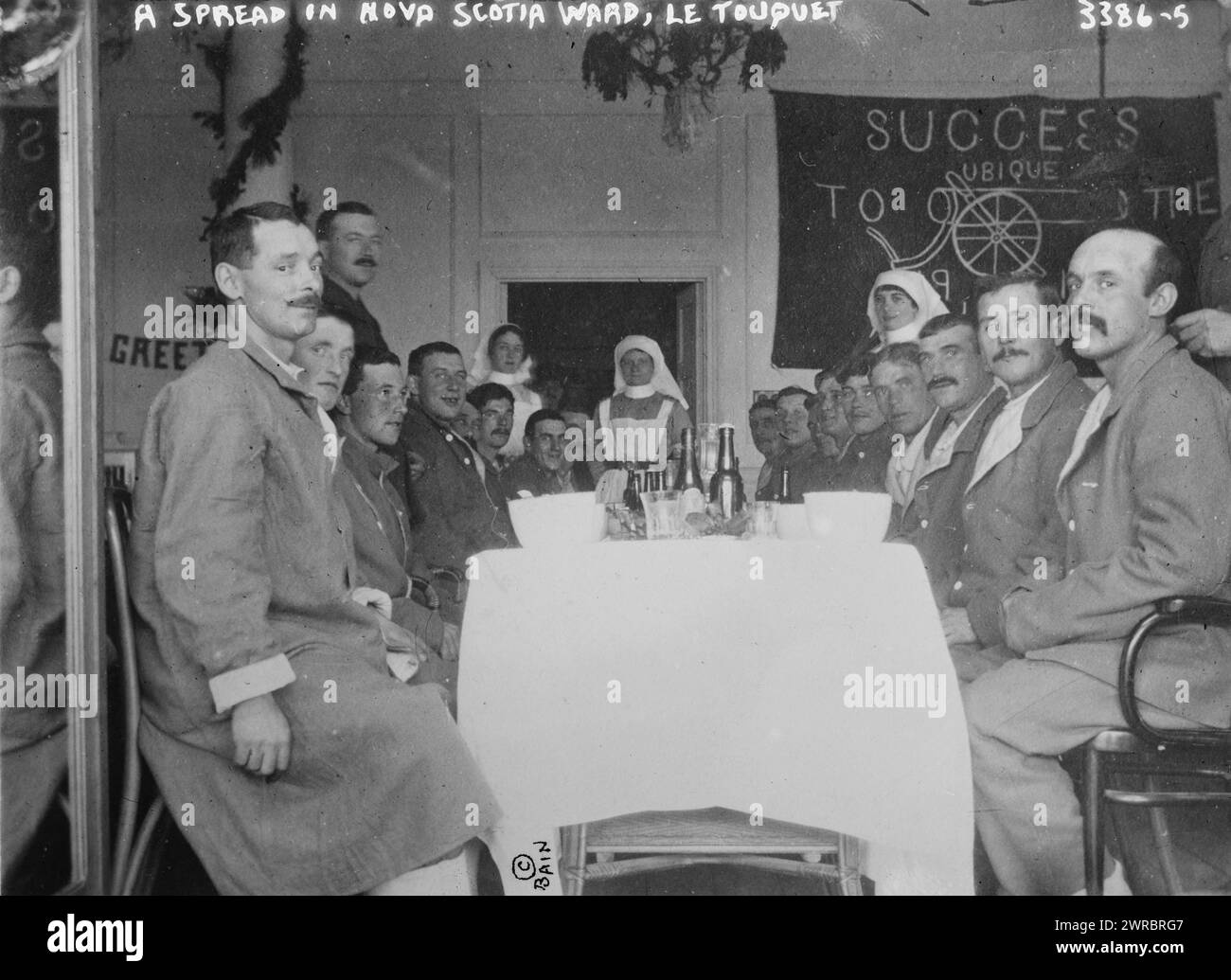 Das Foto zeigt Soldaten, die während des Ersten Weltkriegs an einem Tisch im kanadischen Basiskrankenhaus im Hotel du Golf in Le Touquet, Frankreich, sitzen Ein Banner im Hintergrund stammt von der Royal Canadian Artillery, zwischen 1914 und ca. 1915, Weltkrieg, 1914-1918, Glasnegative, 1 negativ: Glas Stockfoto
