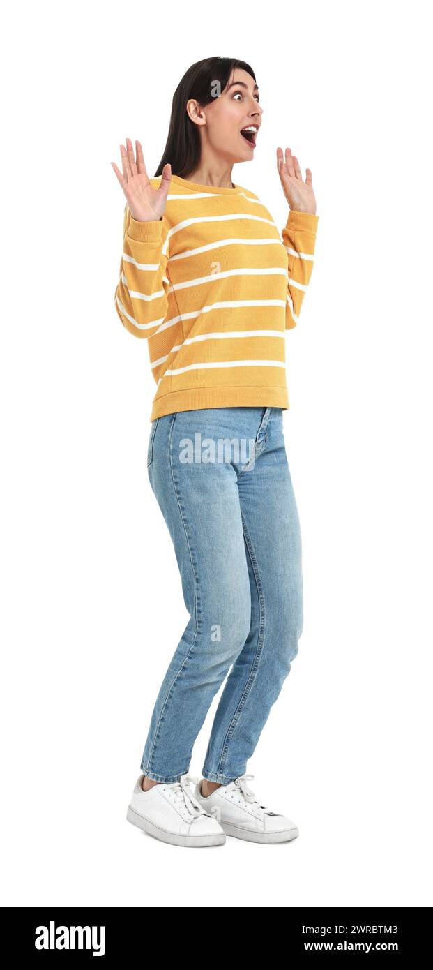 Überraschte Frau in Jeans und Pullover auf weißem Hintergrund Stockfoto
