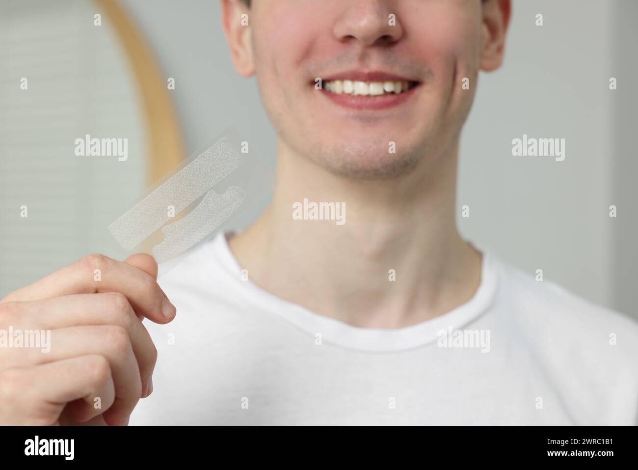 Junger Mann mit Aufhellungsstreifen drinnen, Nahaufnahme Stockfoto