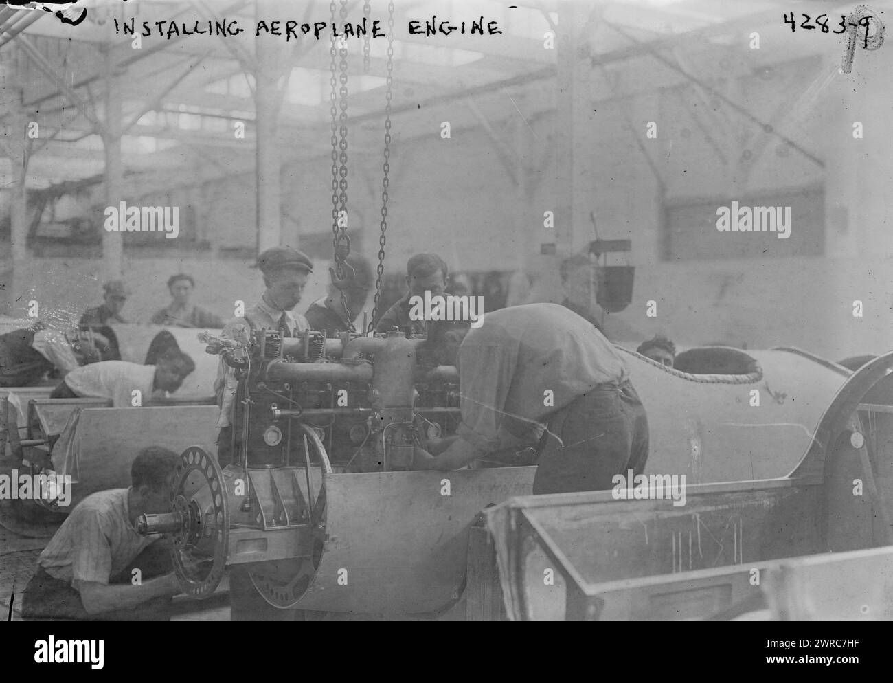 Installation eines Flugzeugtriebwerks, Foto zeigt Arbeiter, die einen Motor in ein Flugzeug setzen, bei der Lowe, Willard & Fowler Engineering Company, College Point, Queens, New York City. Zwischen ca. 1915 und ca. 1920, Glasnegative, 1 negativ: Glas Stockfoto