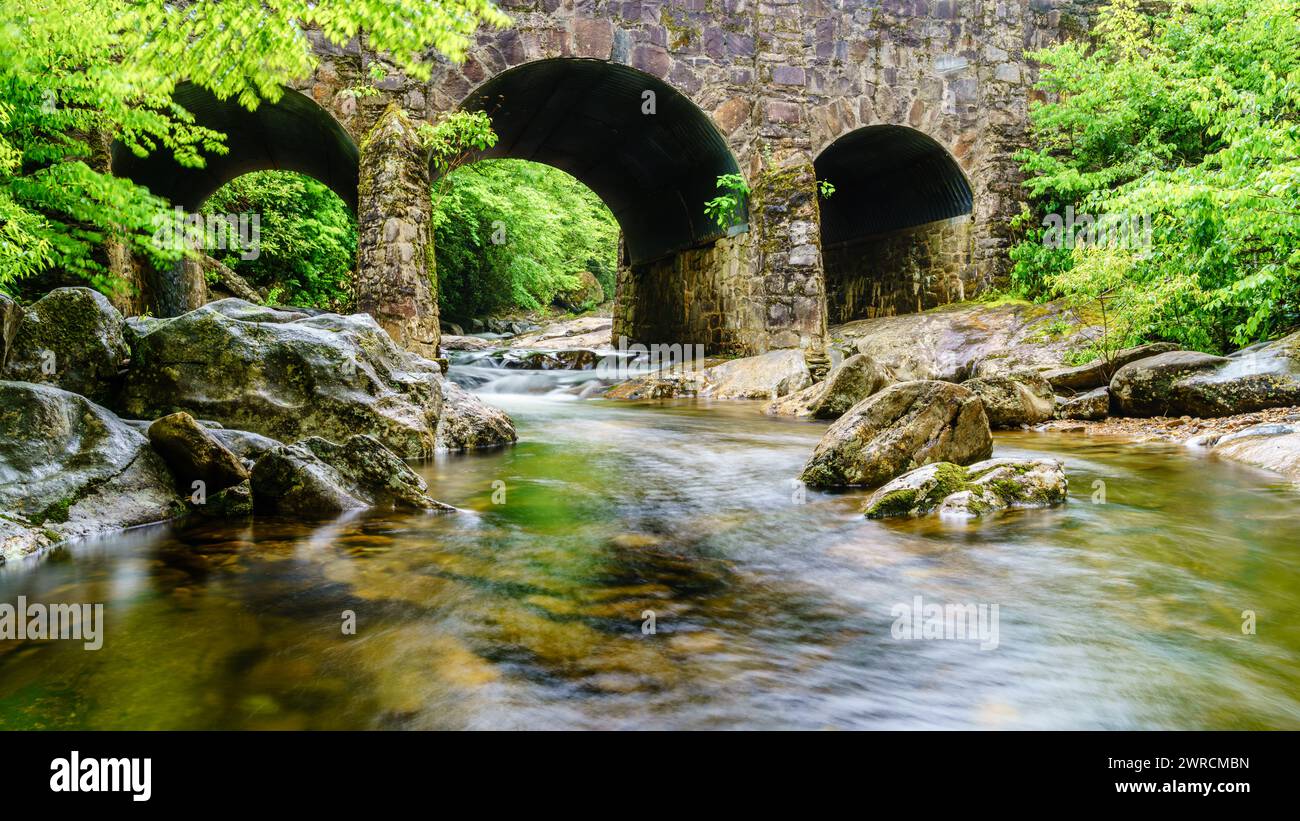 Langzeitbelichtung des West Fork Pigeon River unter der Triple Arch Bridge in der Nähe von Maggie Valley, North Carolina. Stockfoto