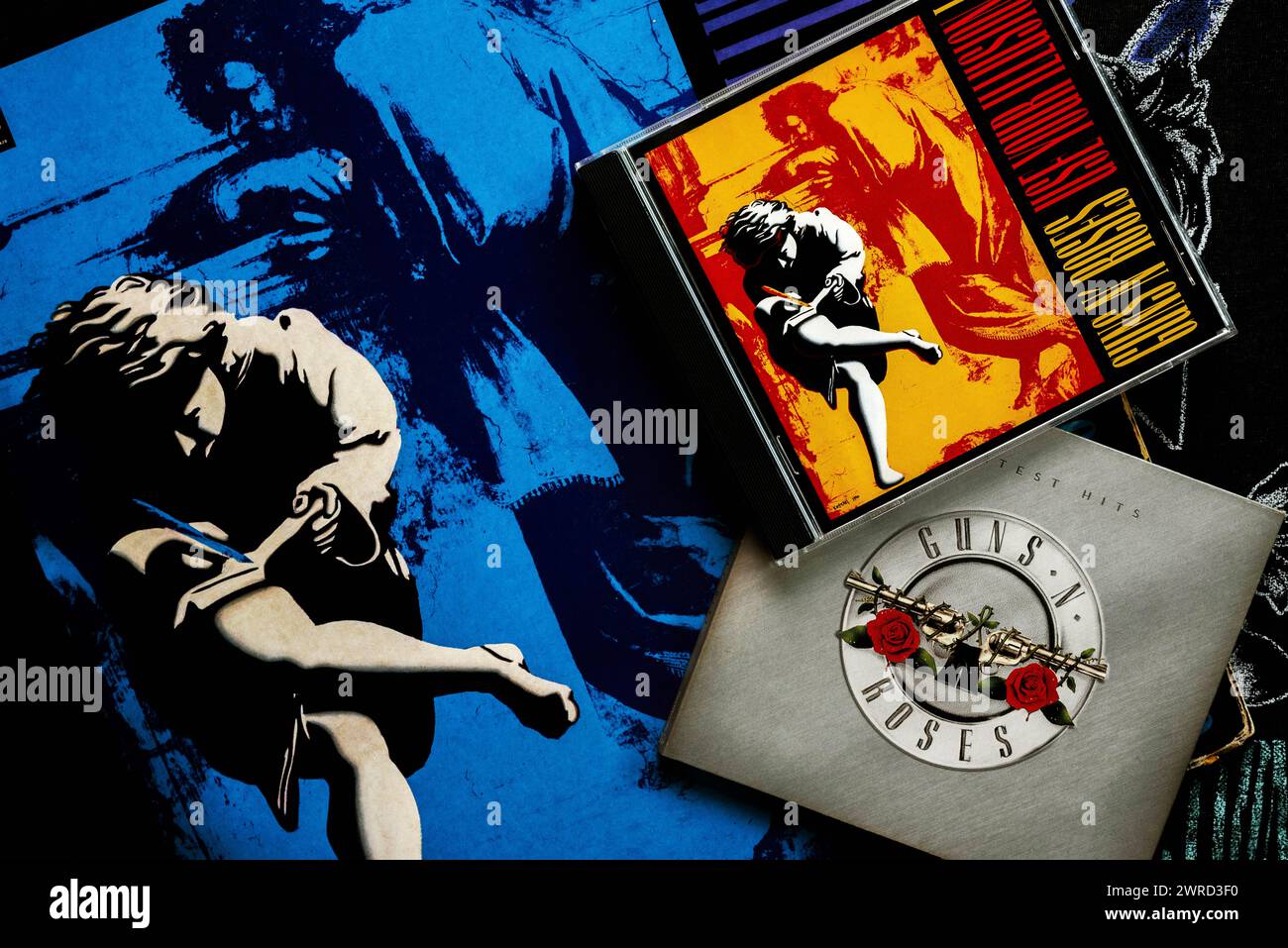 Nahaufnahme von Vinyl lp Verwenden Sie Ihre Illusion der amerikanischen Heavy-Metal-Gruppe Guns and Roses und cds auf einem T-Shirt. Illustrativer Leitartikel Stockfoto