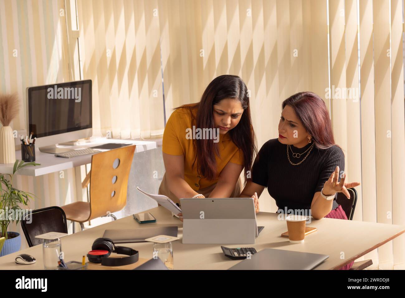 Zwei Geschäftsfrauen diskutieren ein Projekt am Arbeitsplatz Stockfoto