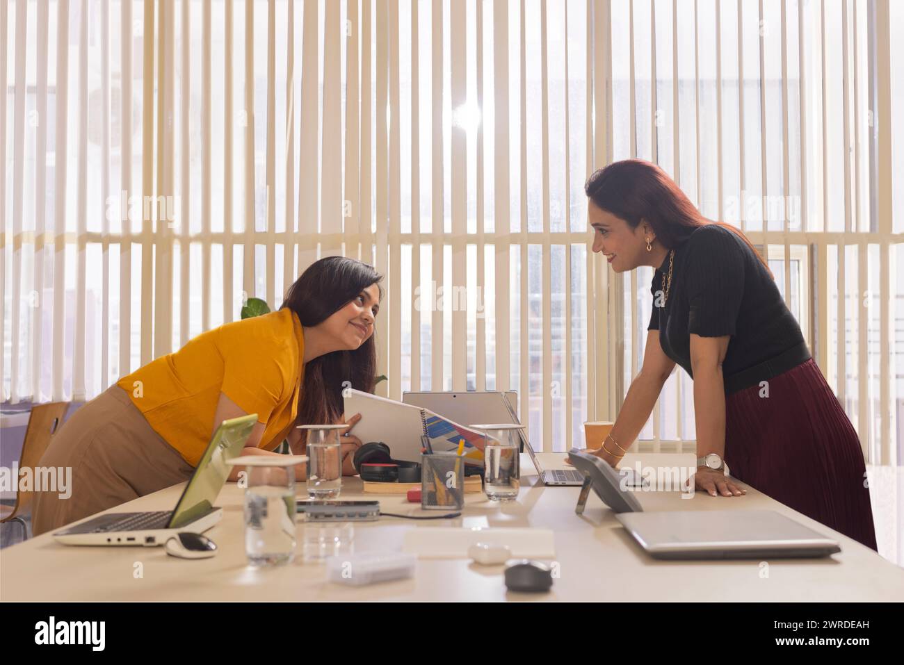 Zwei Geschäftsfrauen arbeiten zusammen am Schreibtisch in einem Büro Stockfoto