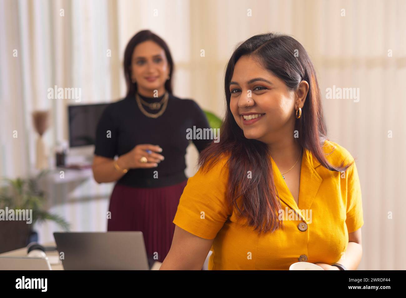 Zwei Geschäftsfrauen diskutieren über ein Projekt auf Laptop am Arbeitsplatz Stockfoto