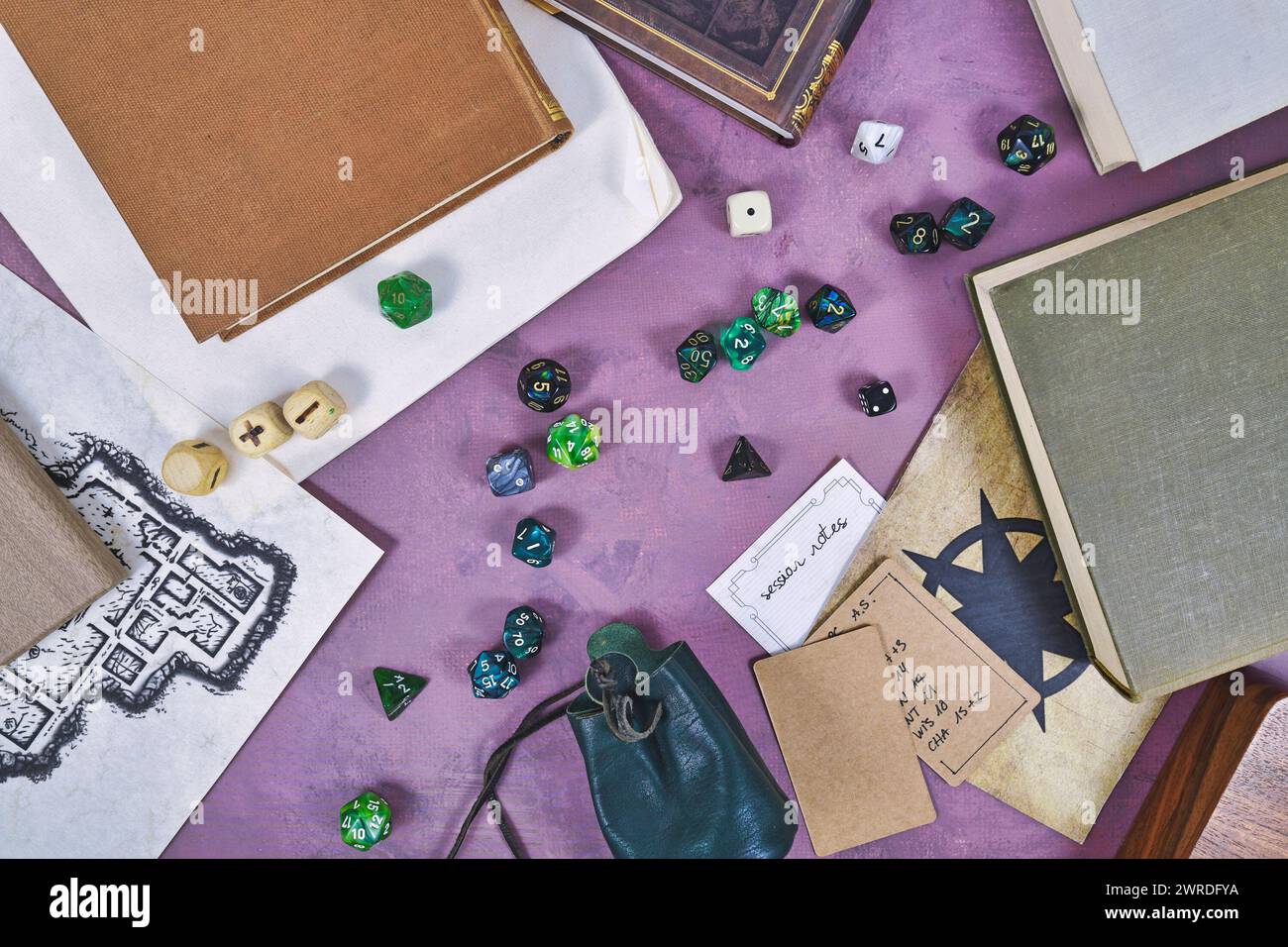 Die Rolle auf der Tischplatte spielt einen flachen Hintergrund mit bunten RPG-Würfeln, Notizen, Regelbüchern und Dungeon-Karte Stockfoto