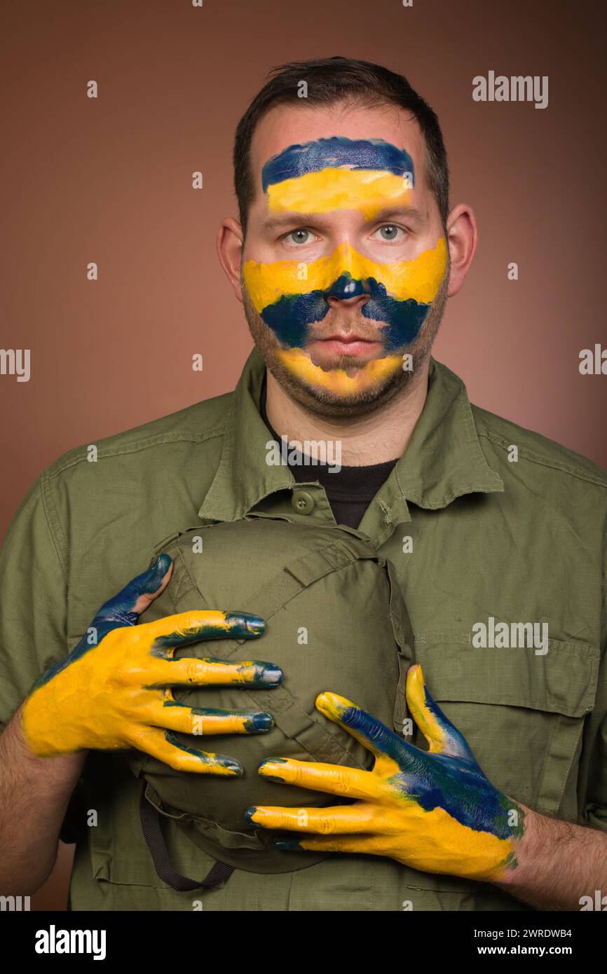 Mann, der Respekt vor der Ukraine mit nationalen Farben im Gesicht ausdrückt Stockfoto