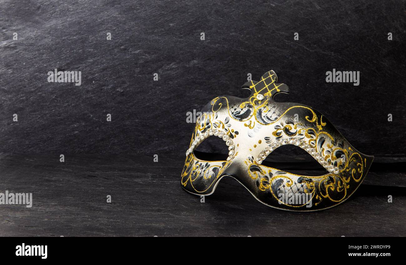 Venezianische Karnevalsmaske auf dunklem Schiefergrund. Stockfoto