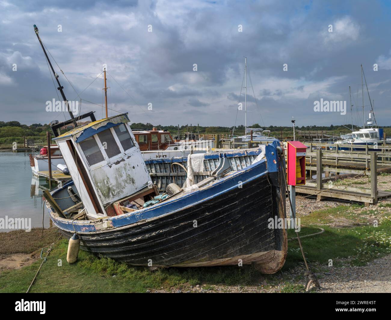 Ein verwittertes Fischerboot, das auf dem River Blyth bei Blackshore, Southwold, Suffolk vor Anker liegt. Stockfoto