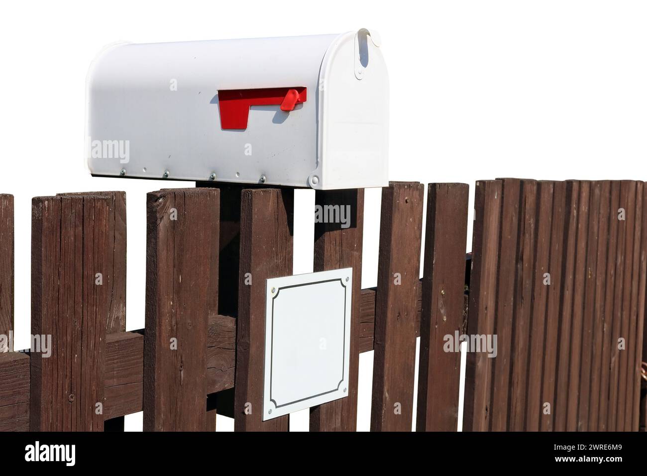 Briefkasten aus Metall, montiert auf einem rustikalen Zaun. Isoliert auf weiß Stockfoto