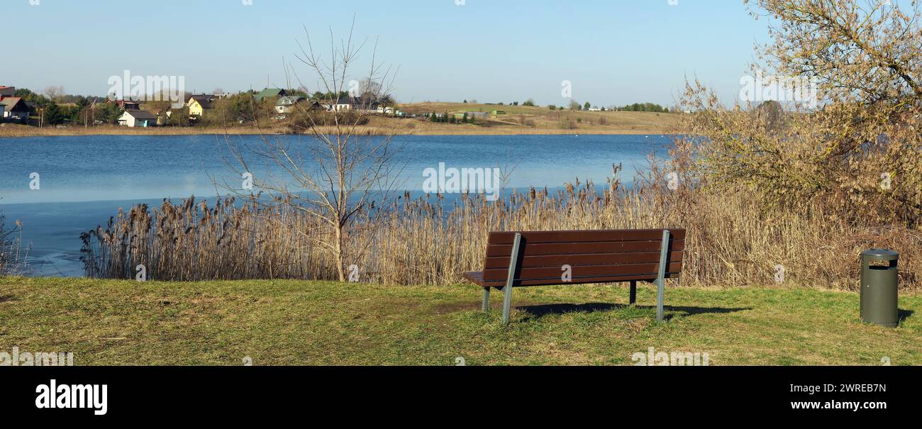 Entspannungsbereich mit Bank am Ufer einer Quellseelandschaft Stockfoto