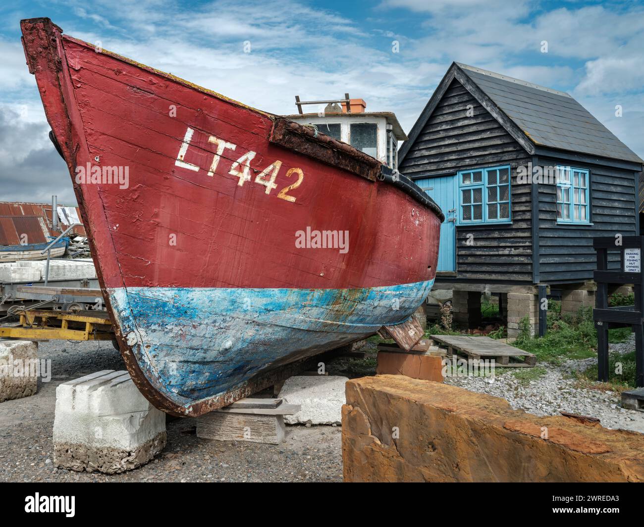 Ein verwittertes Fischerboot im Trockendock am Ufer des River Blyth bei Blackshore, Southwold, Suffolk. Stockfoto