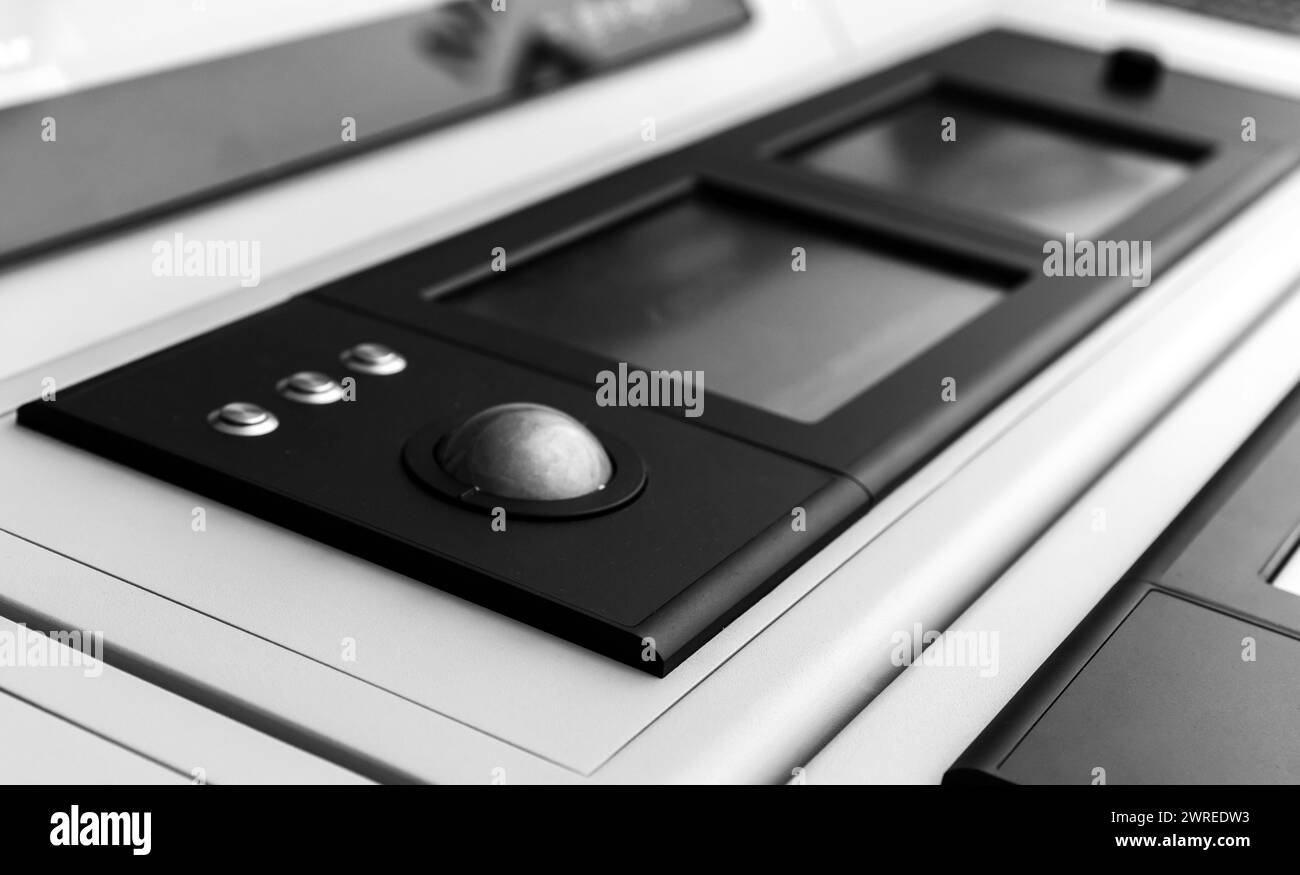 Integriertes Tischgerät mit Trackball-Maus und digitalen Touchscreens. Schwarzweißfoto mit selektivem Fokus Stockfoto