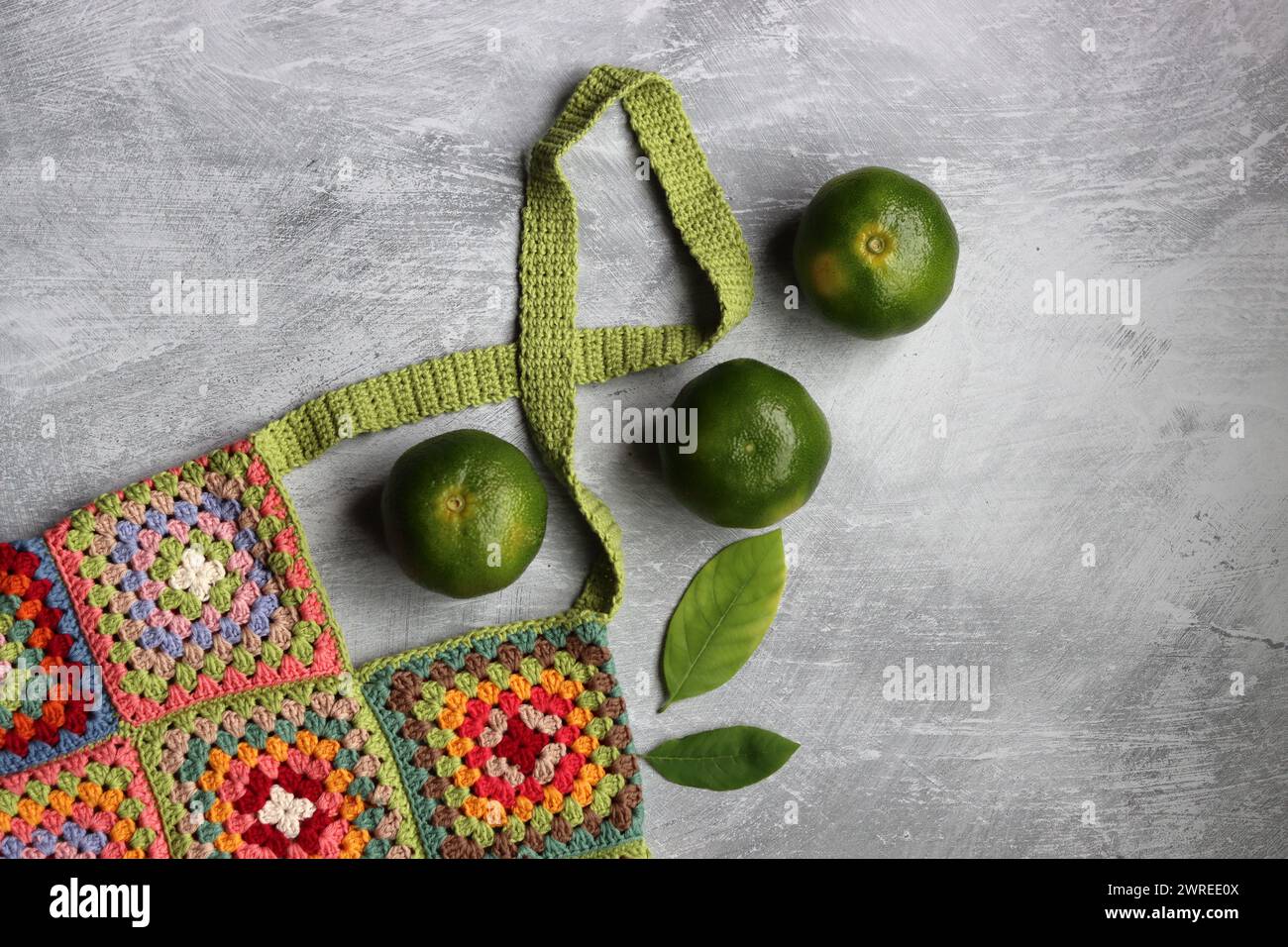 Bunte Einkaufstasche aus Bio-Baumwolle. Häkeln Sie die Textur aus der Nähe des Fotos. Umweltfreundliche Tasche. Quadratisches Granny-Muster. Stockfoto