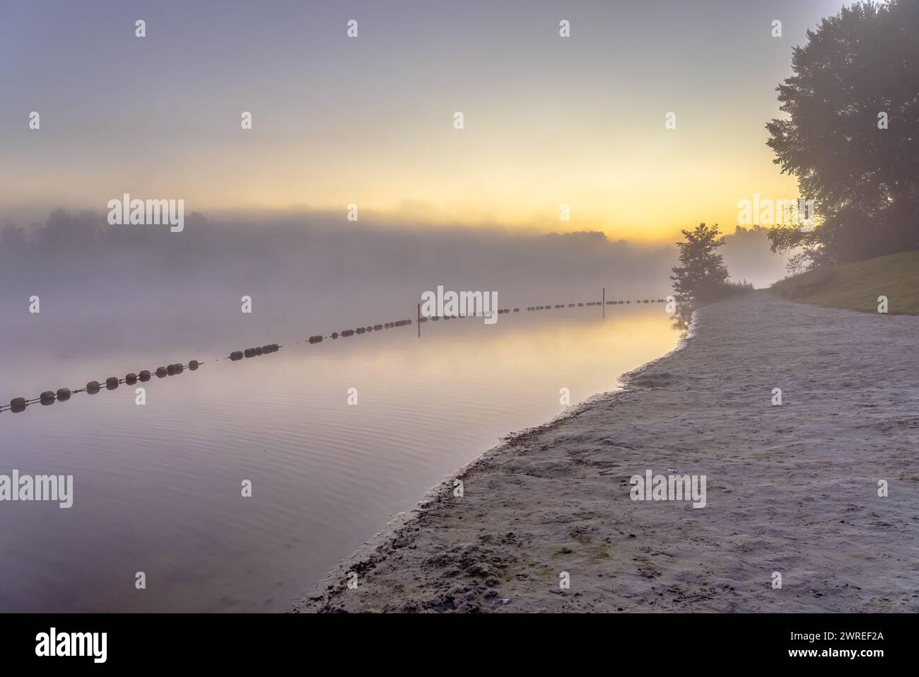 Wunderschöner kleiner Erholungssee mit Badebereich mit Schwimmern bei Sonnenaufgang im Sommer. Niederlande. Stockfoto