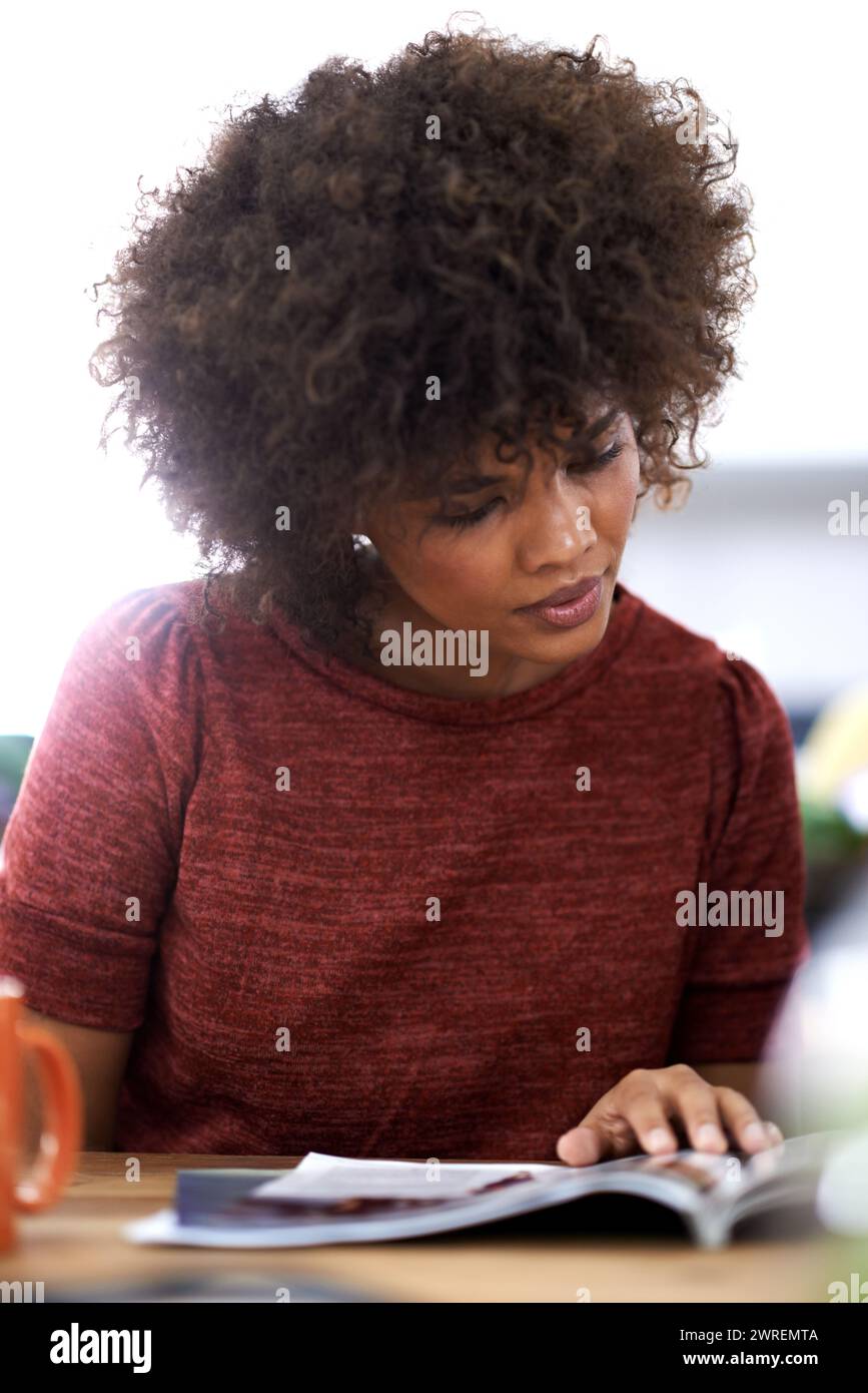 Schwarze Frau, Afro und Lesen mit Zeitschrift für Mode, Stil oder Literatur im Büro. Afrikanische weibliche Person oder kreative Angestellte mit Roman Stockfoto