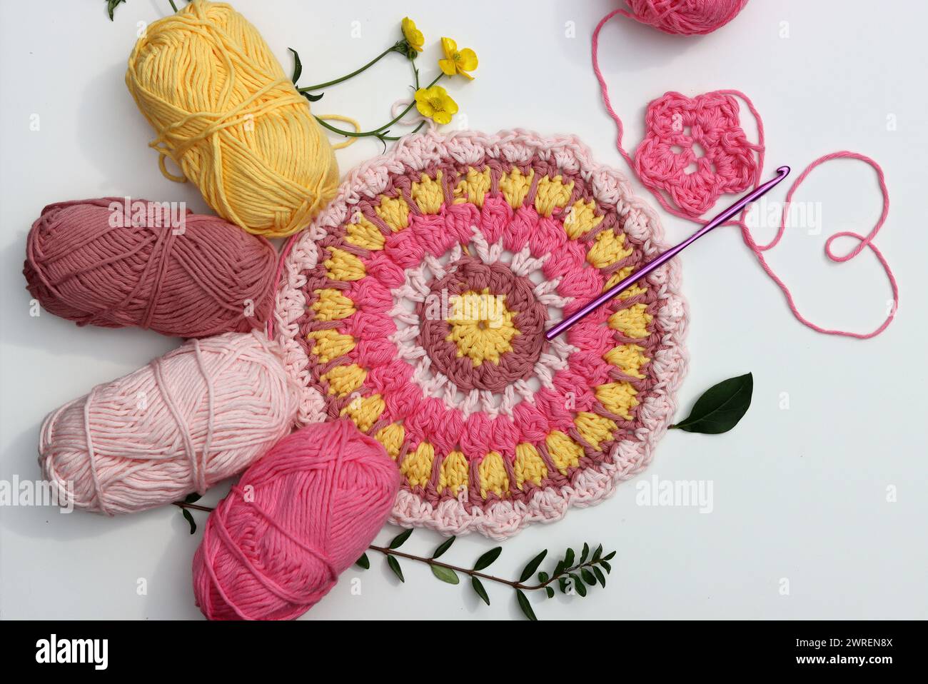 Rosafarbenes Häkeln. Handgefertigtes Ornament aus rosa Bio-Garn. Weißer Hintergrund mit Kopierraum. Hobby-Konzept. Stockfoto