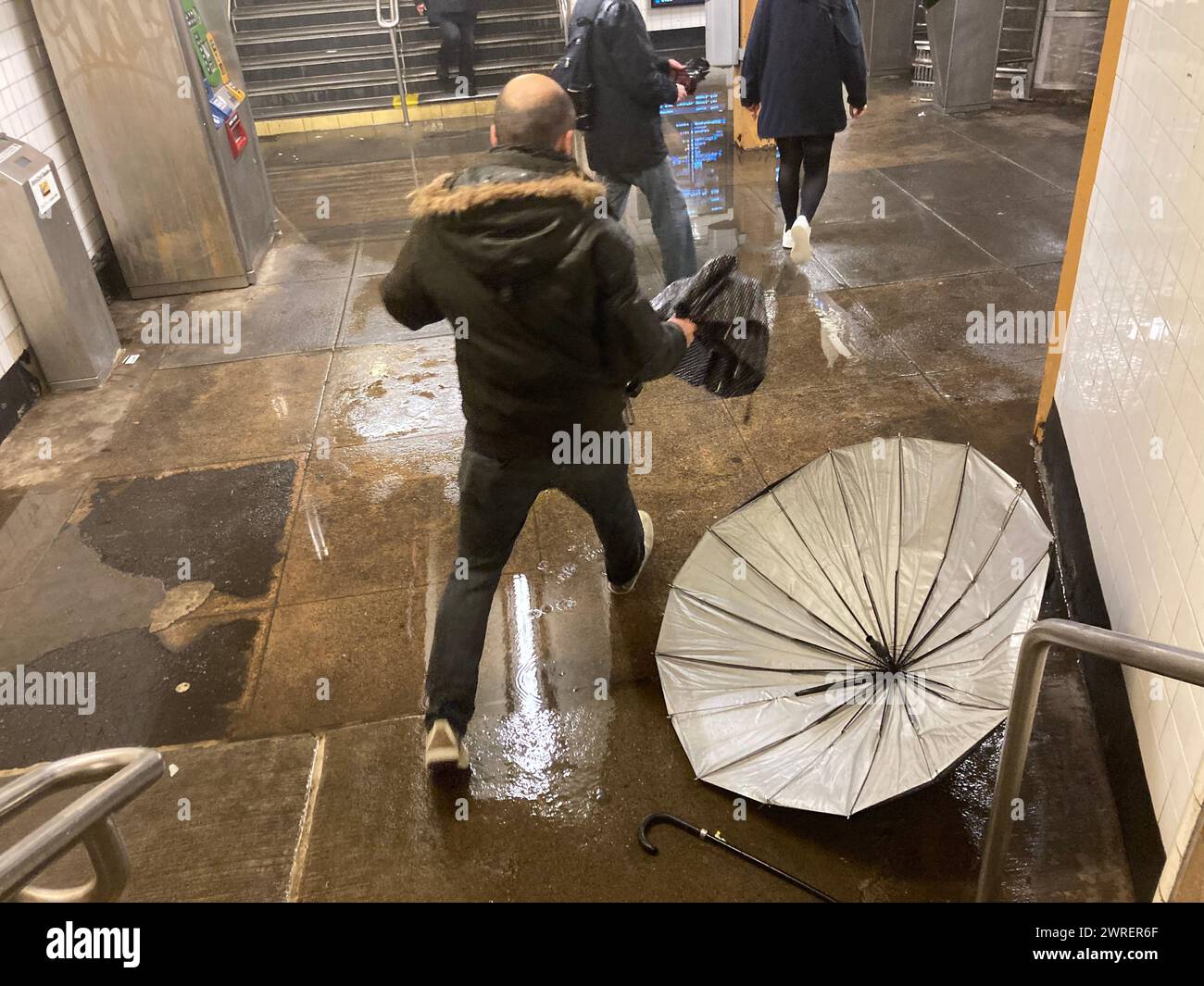 Puddlespringer betreten die 23rd Street Station in Chelsea in New York während eines Regensturms am Mittwoch, den 6. März 2024. (© Frances M. Roberts) Stockfoto