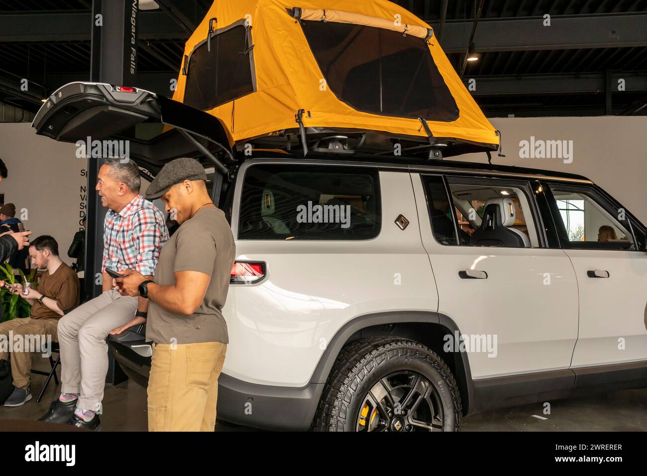 Automobilbegeisterte bewundern den elektrischen Rivian R1S bei einer Ankündigung eines neuen R2-Fahrzeugs am Donnerstag, den 7. März 2024, im Rivian Spaces im Meatpacking District in New York. Neben dem neuen Elektrofahrzeug, das 2026 erhältlich war, führte das Unternehmen den R3 ein, der zu einem noch unbestimmten Zeitrahmen erhältlich war. (© Richard B. Levine) Stockfoto