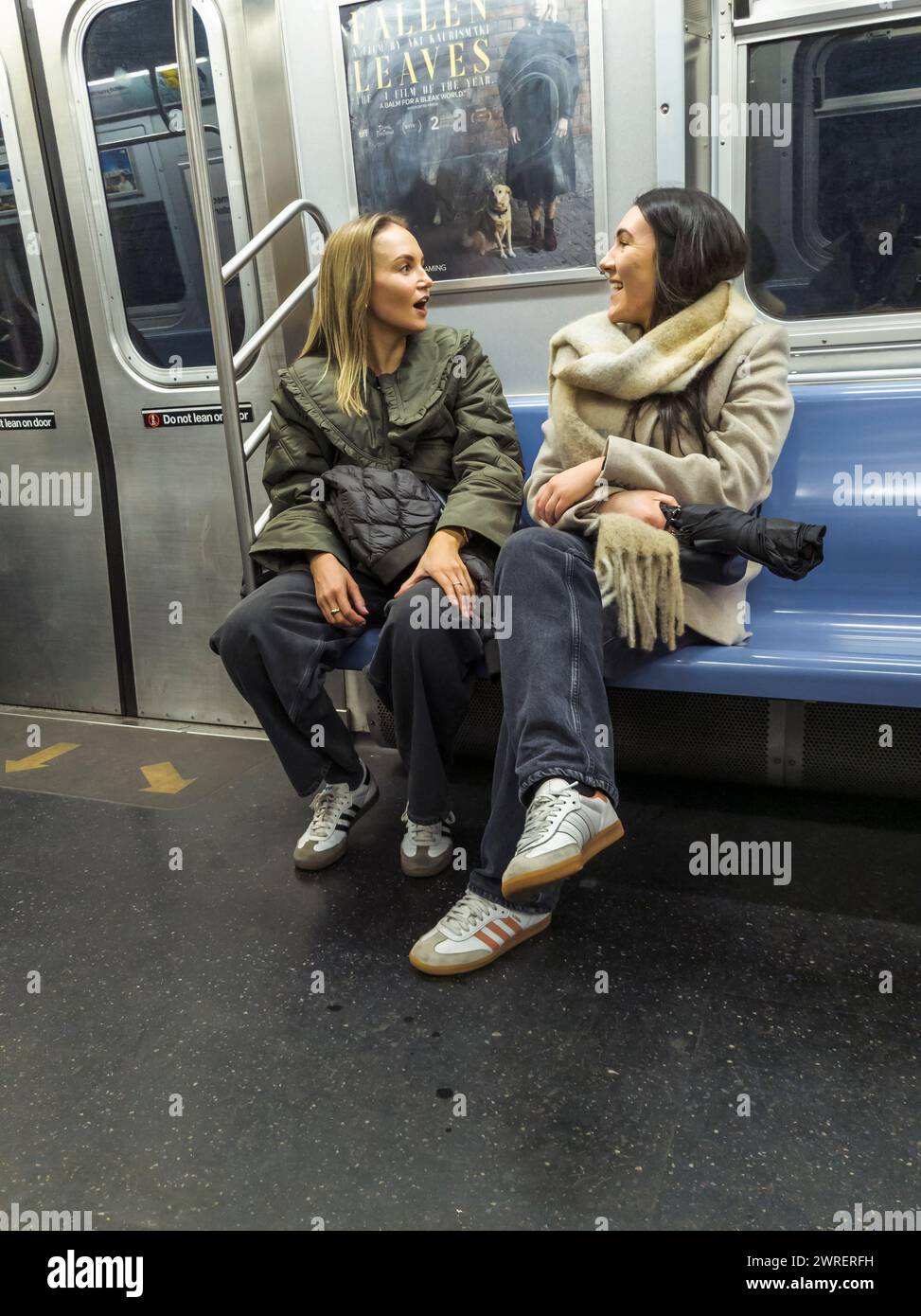 Abgelenkte Reisende im Gespräch in der New Yorker U-Bahn am Samstag, den 9. März 2024. (© Richard B. Levine) Stockfoto