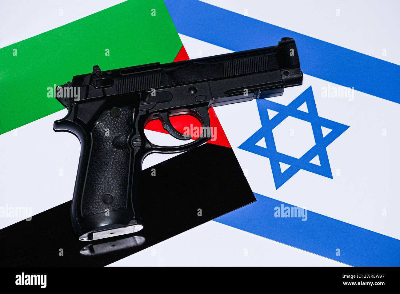 Der Konflikt zwischen Israel und Palästina ist noch nicht vorbei. Das Bild mit den beiden Fahnen, auf denen eine Pistole mit einer Kugel drauf ist, was uns das zeigt Stockfoto