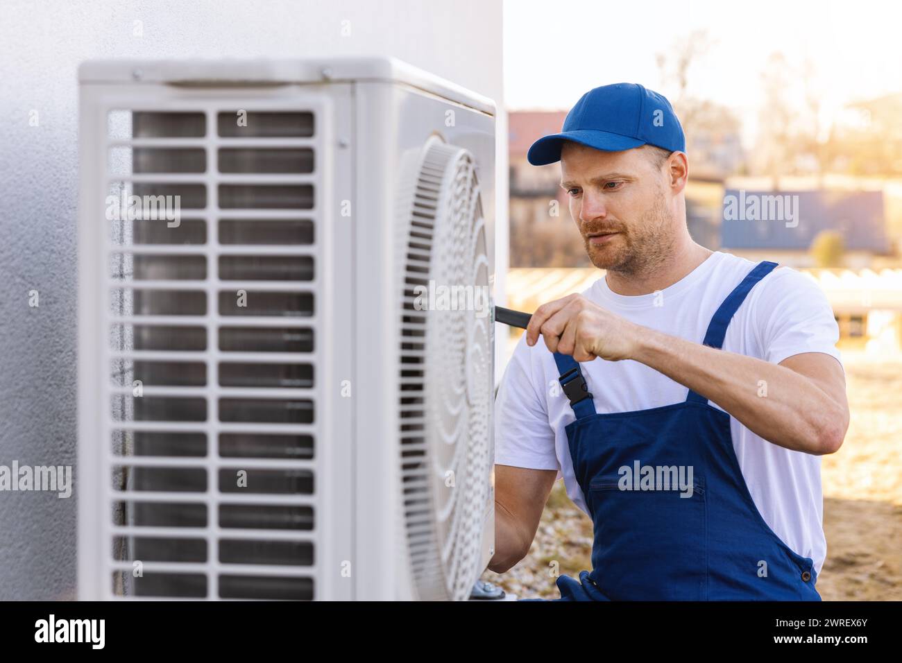 Techniker, der an der Klimaanlage oder an der Außeneinheit mit Wärmepumpe arbeitet. Wartung, Wartung und Reparatur der Klimaanlage Stockfoto