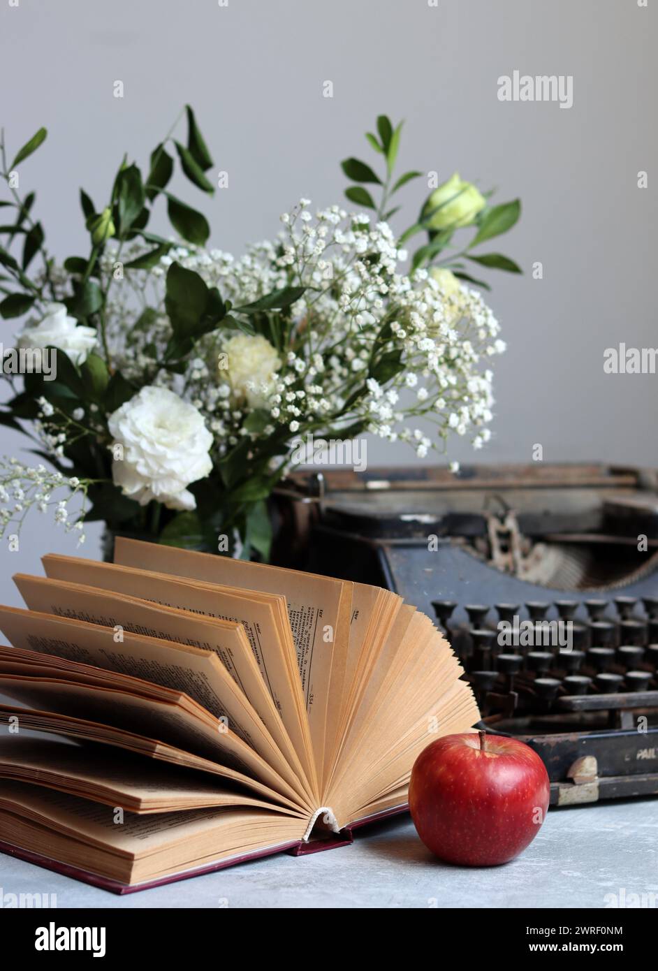 Stillleben im Retro-Stil mit offenem Buch auf dem Schreibtisch. Nahaufnahme von Vintage-Objekten. Stockfoto