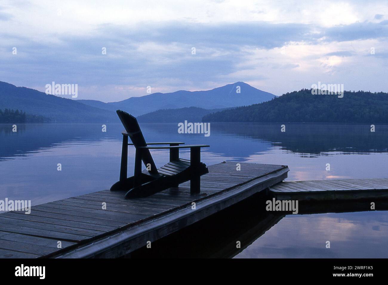 Adirondack-Stuhl auf einem Jetty am See. Stockfoto