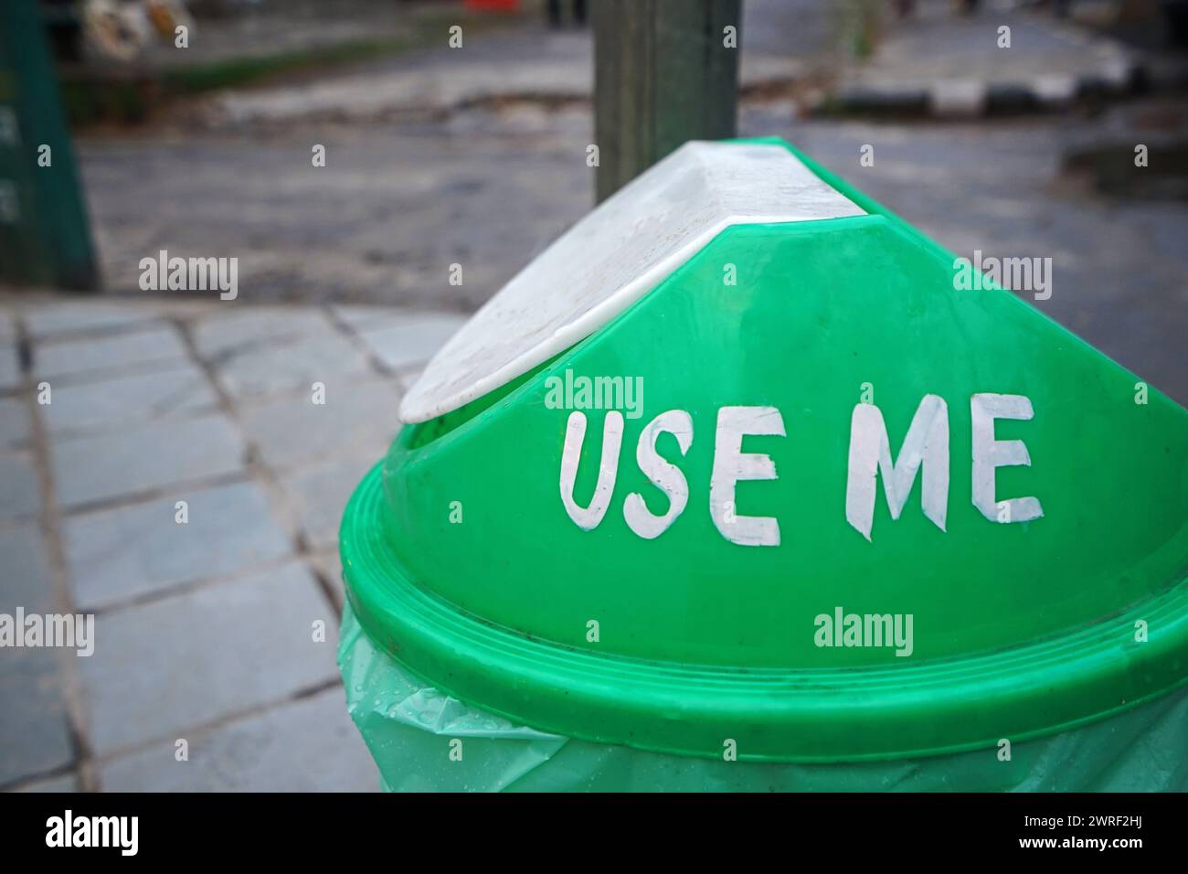 Schließen Sie den grünen Plastikmüll mit dem Text „USE ME“ auf dem Deckel Stockfoto