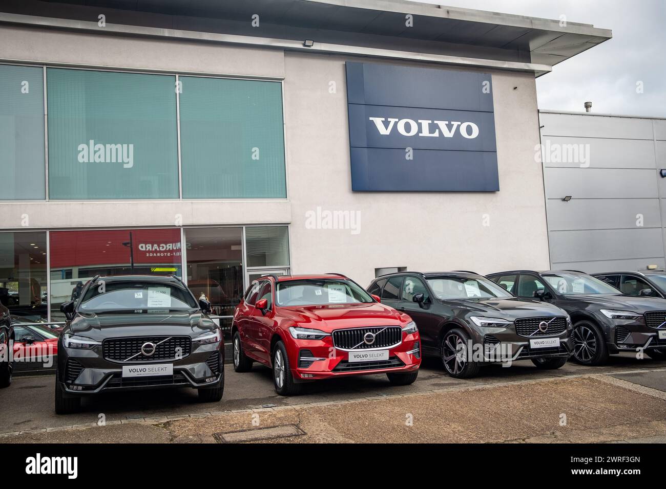 LONDON – 4. FEBRUAR 2024: Fahrzeuge des Volvo Autohändlers parken vor dem Ausstellungsraum mit dem Volvo-Logo oben. Schwedischer Fahrzeughersteller. Stockfoto