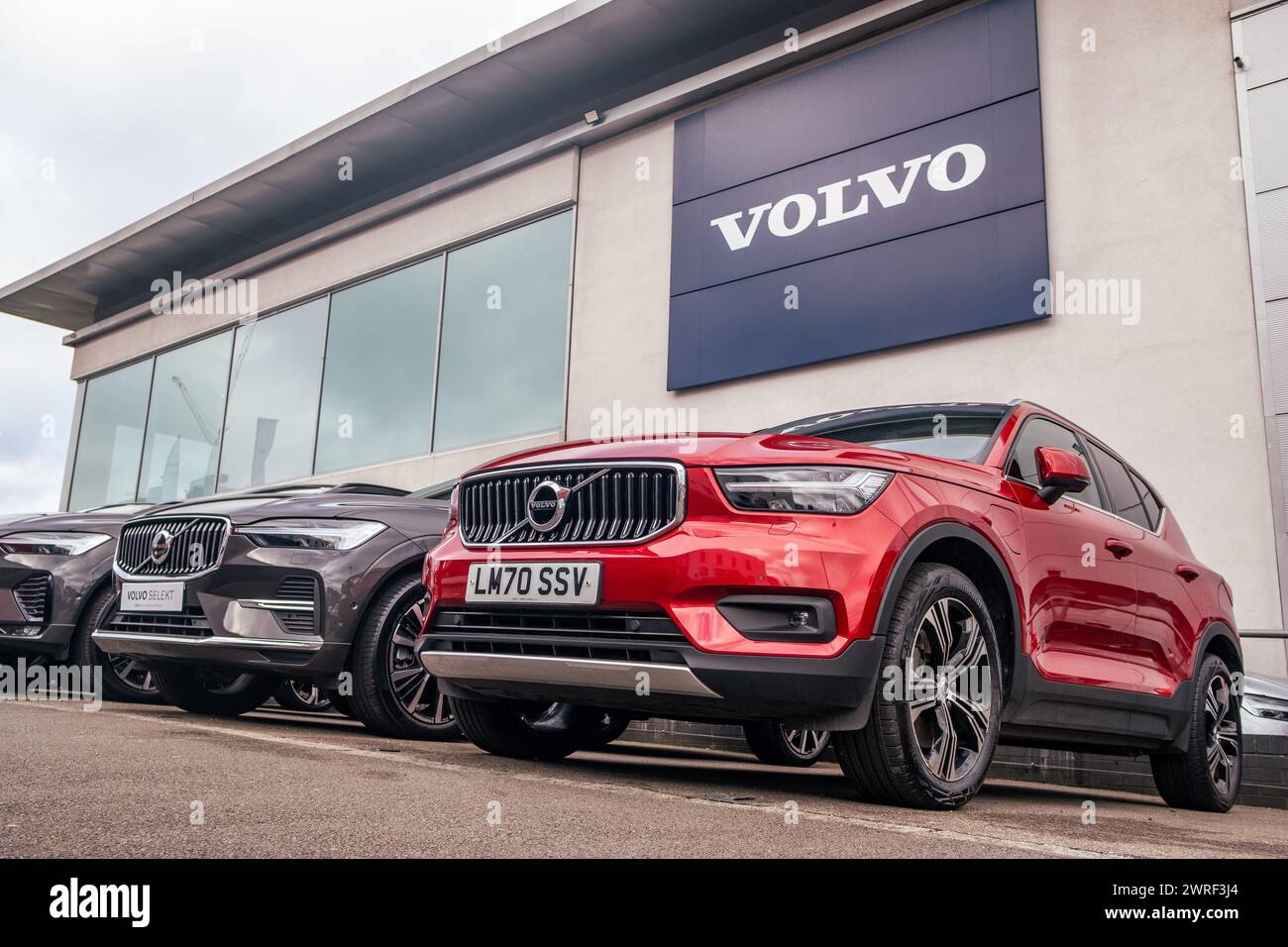 LONDON – 4. FEBRUAR 2024: Fahrzeuge des Volvo Autohändlers parken vor dem Ausstellungsraum mit dem Volvo-Logo oben. Schwedischer Fahrzeughersteller. Stockfoto