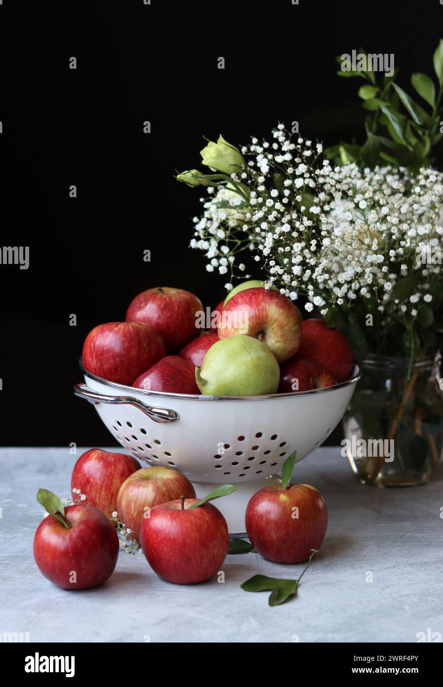Stillleben Foto mit roten Äpfeln und weißen Blumen. Harvest Festival Konzept. Frisches Obst aus der Farm aus nächster Nähe. Stockfoto