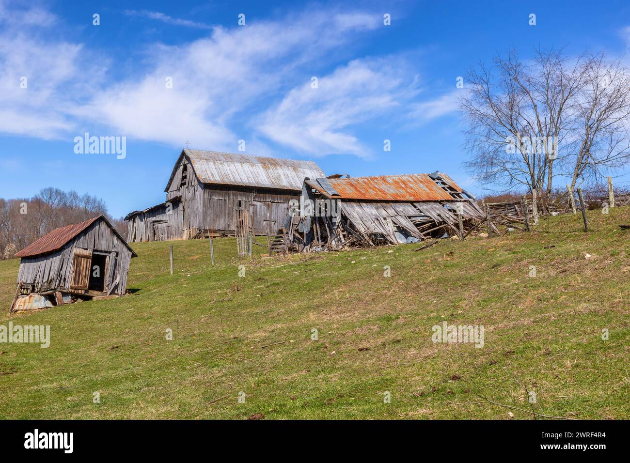 Links zu den äußeren Elementen sitzen diese landwirtschaftlichen Gebäude auf einem Hügel, der verfällt. Stockfoto