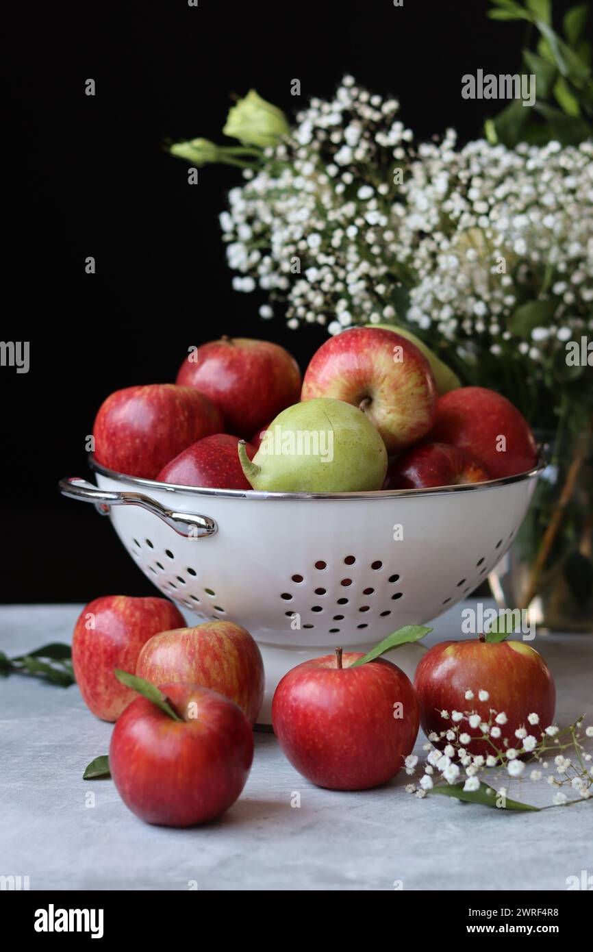 Stillleben Foto mit roten Äpfeln und weißen Blumen. Harvest Festival Konzept. Frisches Obst aus der Farm aus nächster Nähe. Stockfoto