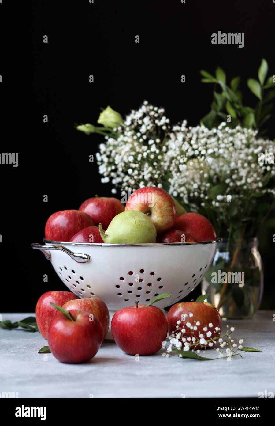 Stillleben Foto mit roten Äpfeln und weißen Blumen. Harvest Festival Konzept. Frisches Obst aus der Farm aus nächster Nähe. Stockfoto