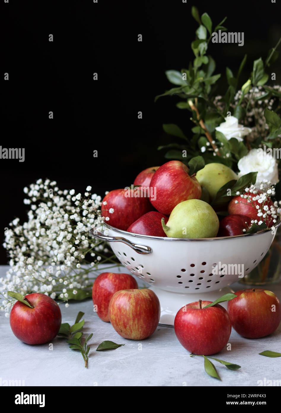 Stillleben Foto mit roten Äpfeln und weißen Blumen. Harvest Festival Konzept. Frisches Obst aus der Farm aus nächster Nähe. Stockfoto
