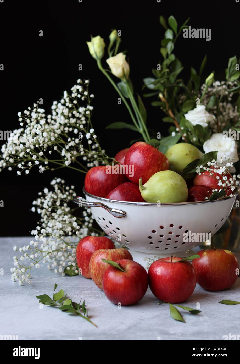 Stillleben Foto mit roten Äpfeln und weißen Blumen. Harvest Festival Konzept. Frisches Obst aus der Farm aus nächster Nähe. Stockfoto