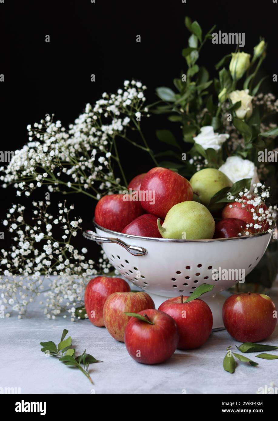 Stillleben Foto mit roten Äpfeln und weißen Blumen. Harvest Festival Konzept. Frisches Obst aus der Farm aus nächster Nähe. Stockfoto