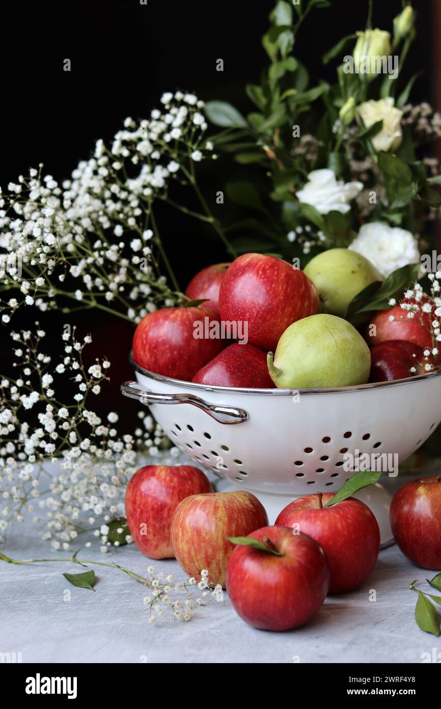 Stillleben Foto mit roten Äpfeln und weißen Blumen. Harvest Festival Konzept. Frisches Obst aus der Farm aus nächster Nähe. Stockfoto