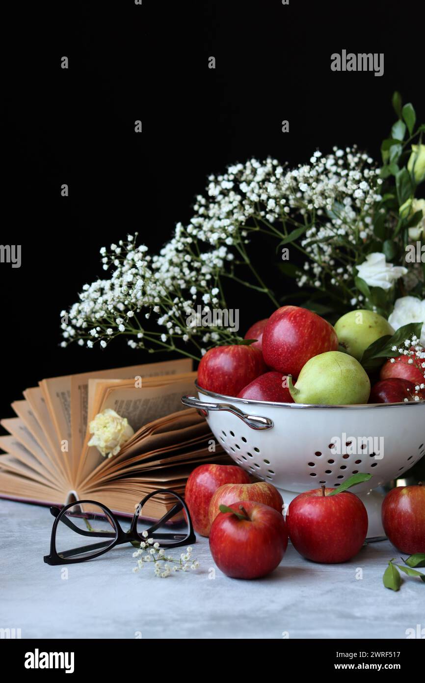 Stillleben Foto mit roten Äpfeln und weißen Blumen. Harvest Festival Konzept. Frisches Obst aus der Farm aus nächster Nähe. Stockfoto