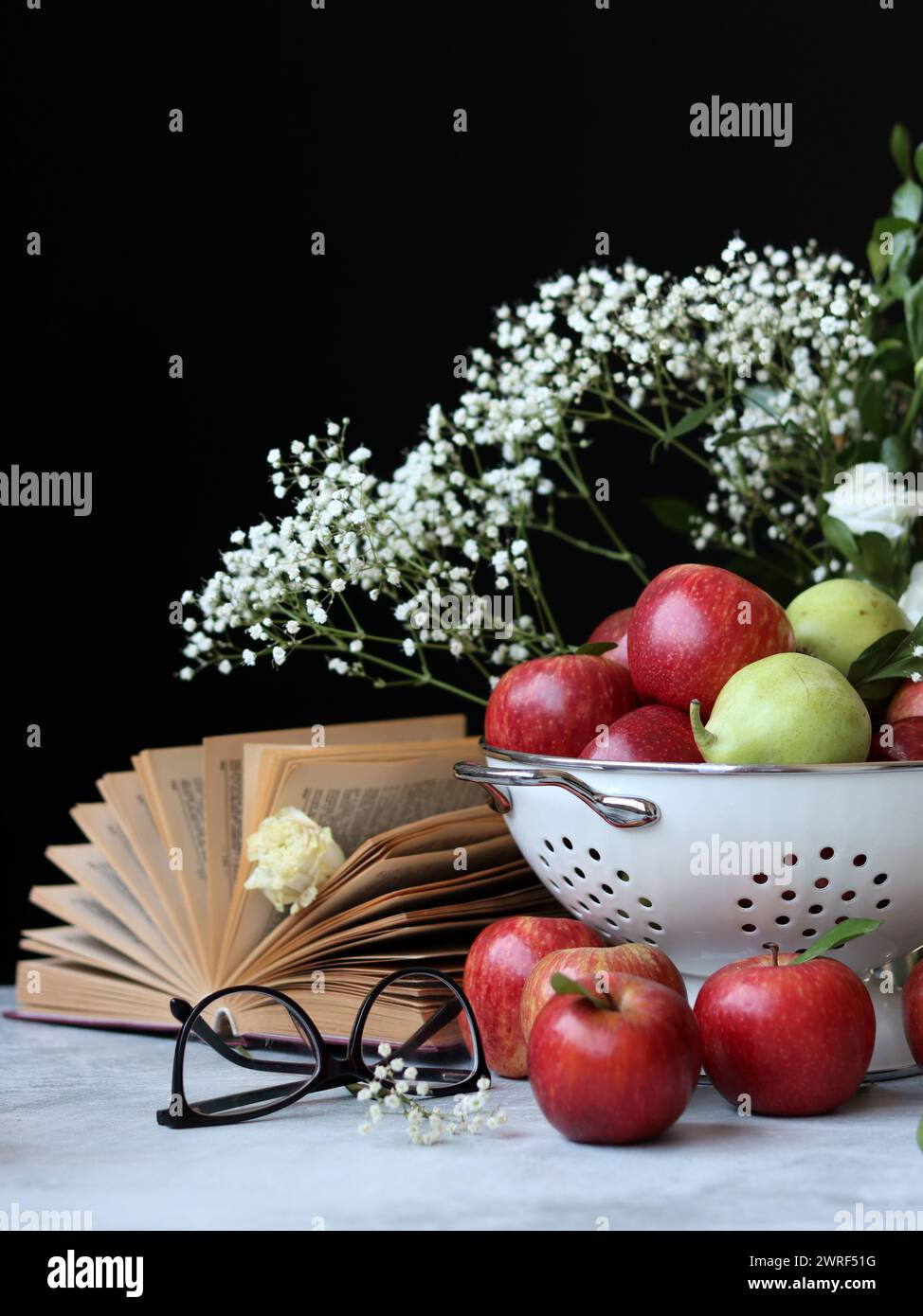 Stillleben Foto mit roten Äpfeln und weißen Blumen. Harvest Festival Konzept. Frisches Obst aus der Farm aus nächster Nähe. Stockfoto