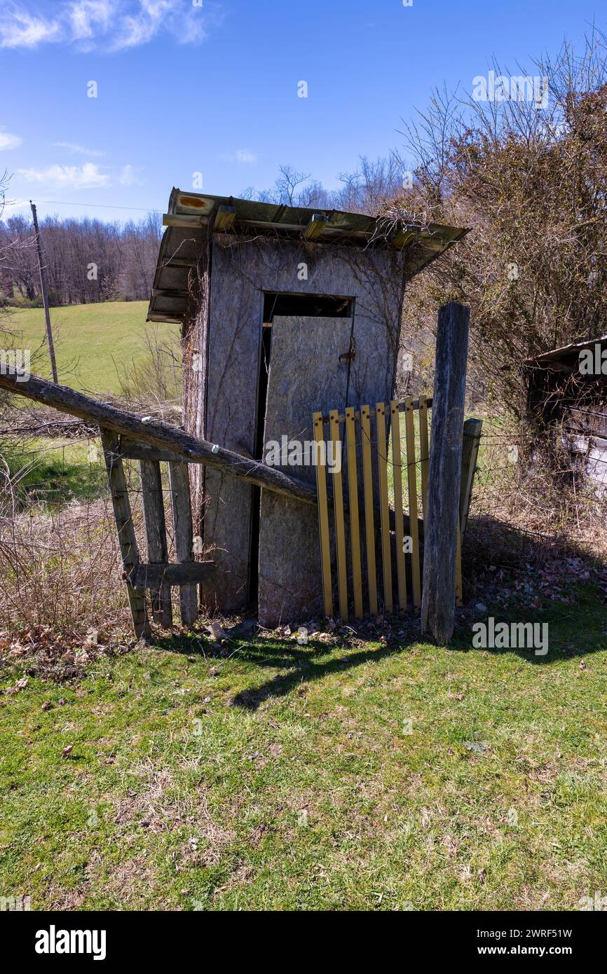 Ein verrottetes altes hölzernes Haus, die Tür fällt von den Scharnieren, sitzt auf einem Hügel im ländlichen Virginia Stockfoto