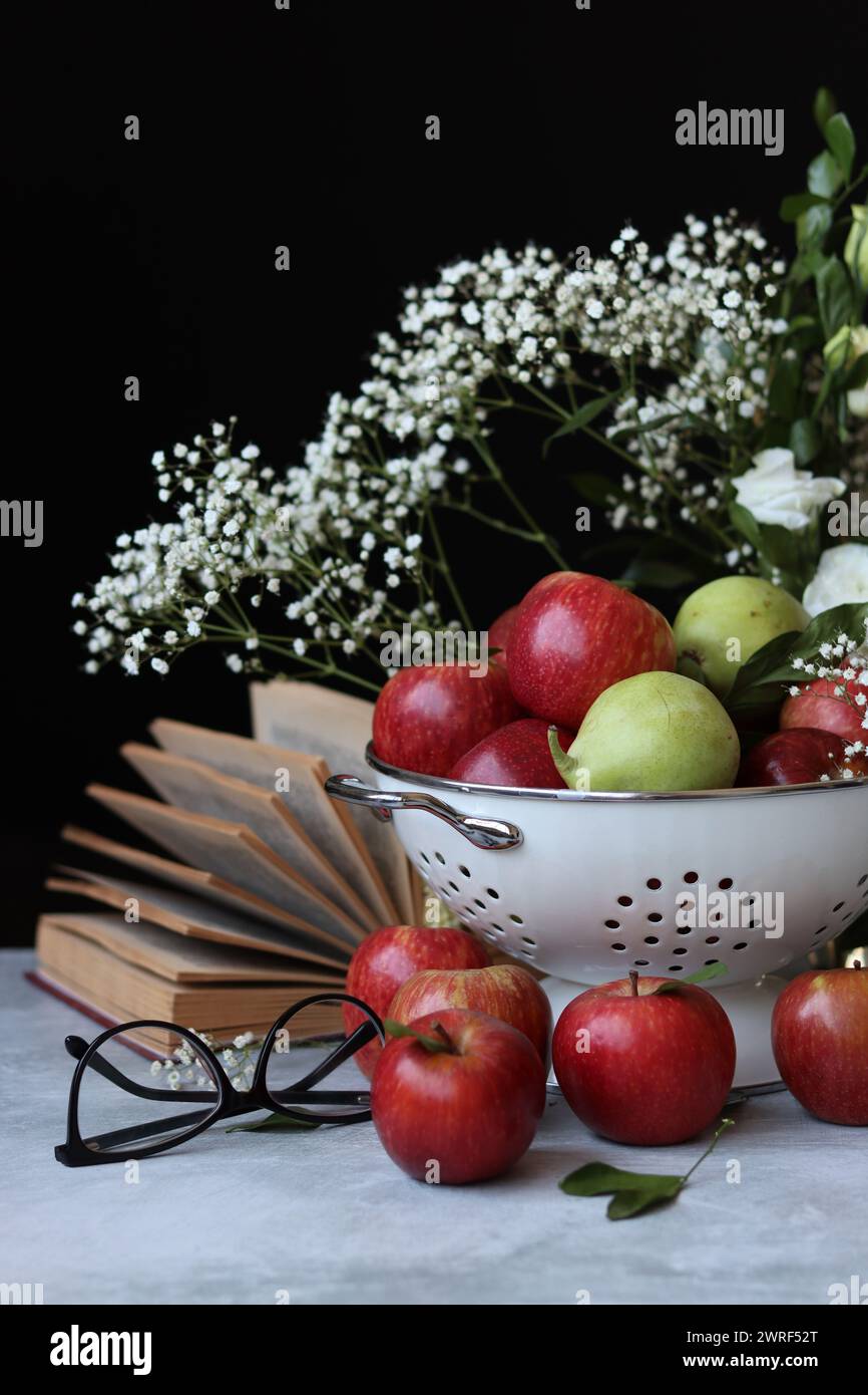 Stillleben Foto mit roten Äpfeln und weißen Blumen. Harvest Festival Konzept. Frisches Obst aus der Farm aus nächster Nähe. Stockfoto