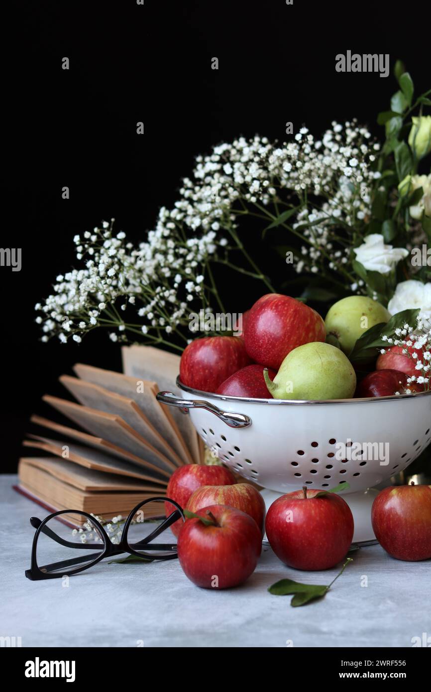 Stillleben Foto mit roten Äpfeln und weißen Blumen. Harvest Festival Konzept. Frisches Obst aus der Farm aus nächster Nähe. Stockfoto
